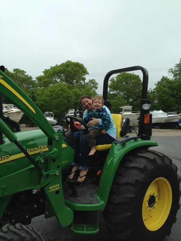 Parent and child on a green tractor