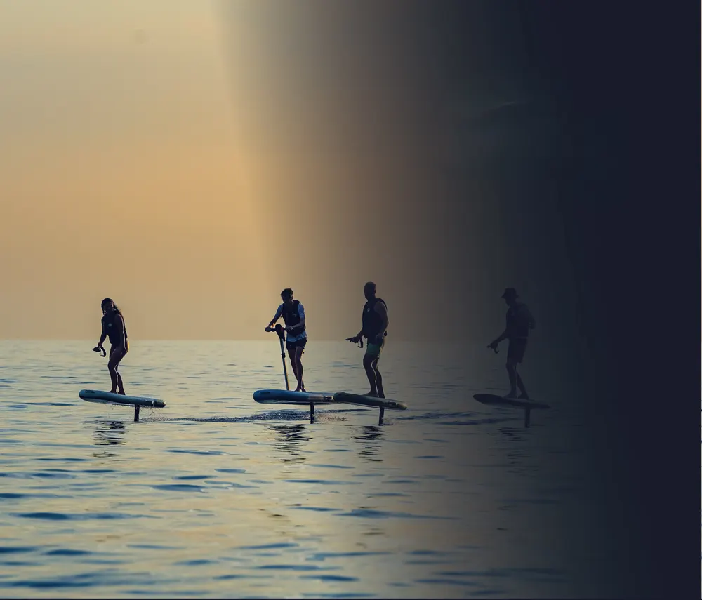 Riders gliding above the water on electric hydrofoil boards