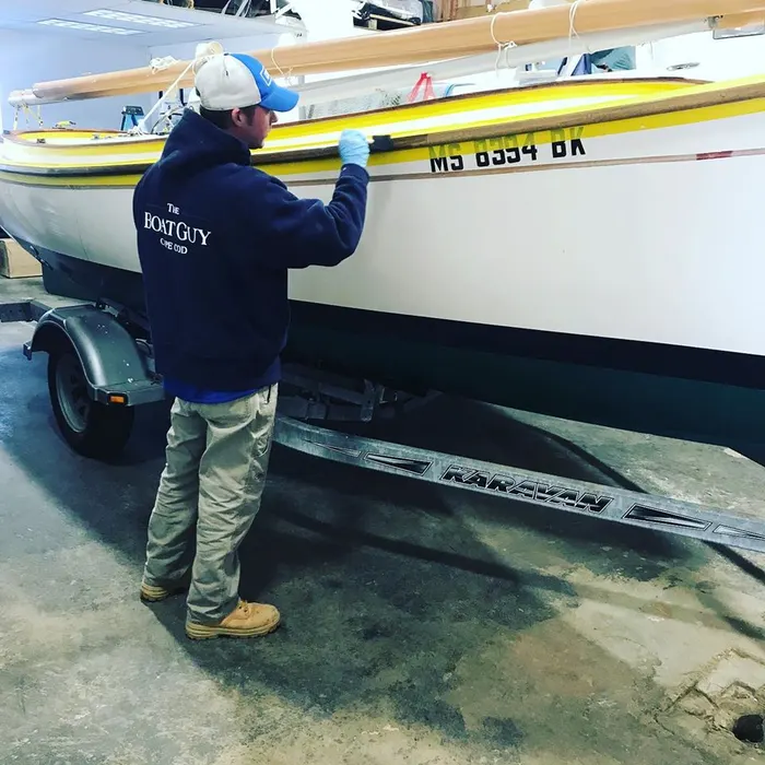 Technician working on a boat hull on its trailer